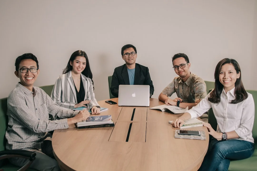 A varied team taking part in discussion during a collaborative office meeting.